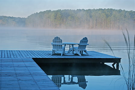 two white wooden adirondack chairs on wooden dock near lake thumbnail