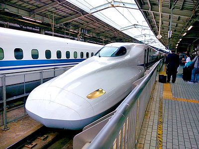 people standing beside white bullet train thumbnail