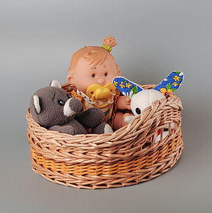 baby doll with pacifier on brown wicker basket thumbnail