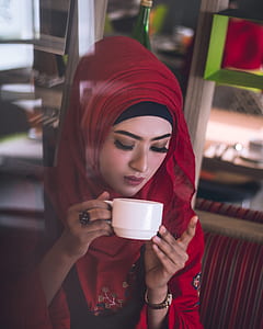 woman holding white ceramic teacup thumbnail