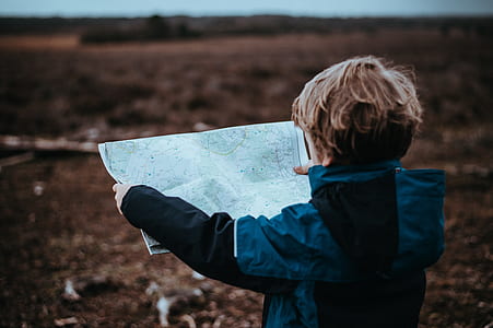 boy holds map at daytime thumbnail