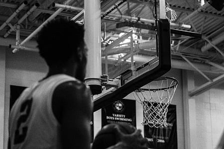 man holding ball under basketball hoop thumbnail