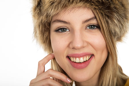 smiling woman touching her face with finger in closeup photography thumbnail