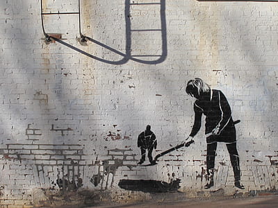 white brick wall with painted person holding shovel thumbnail