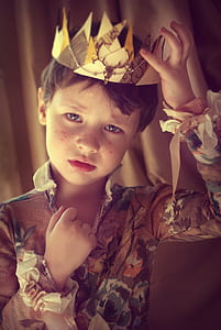 boy wearing floral long-sleeved shirt touching crown on his head thumbnail