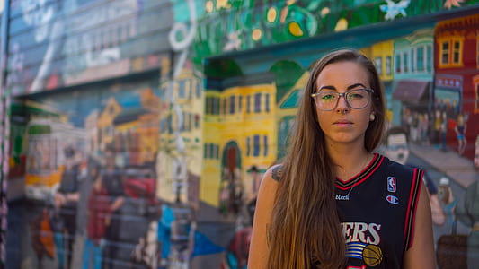 woman standing in front graffiti wall thumbnail