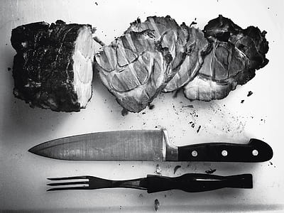 sliced meat beside kitchen knife and tong on chopping board thumbnail