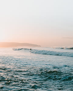 man surfing on body of water during daytime thumbnail