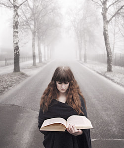woman in black dress reading book on road during daytime thumbnail