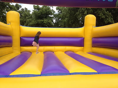 girl jumping on yellow and purple inflatable bouncer thumbnail
