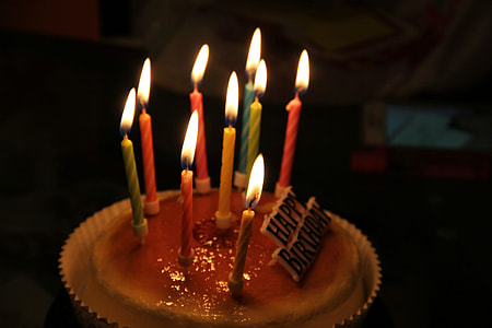 brown icing-covered cake with lighted candles thumbnail