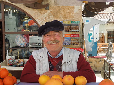 man standing in front of orange fruit thumbnail