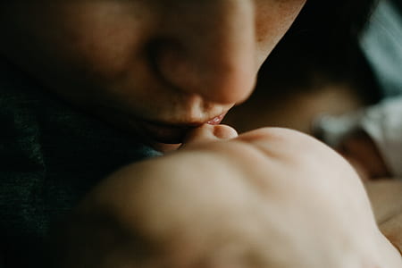 closeup photography of woman kissing a baby thumbnail