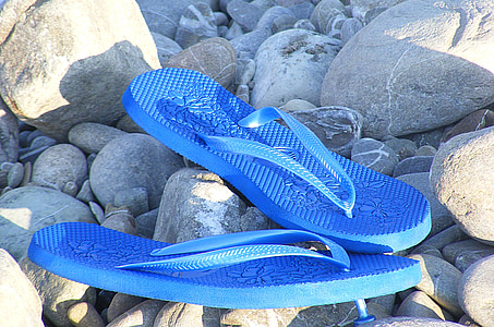 pair of blue flip-flops beside rocks thumbnail