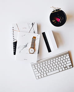 Apple Magic keyboard near round gold-colored wristwatch on white surface thumbnail