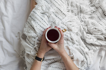 Soft photo of woman on the bed with the book and cup of coffee in hands thumbnail