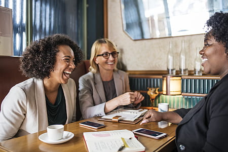 three women sitting on front of table thumbnail