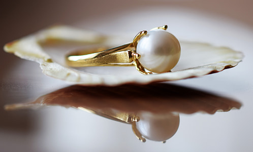 gold-colored ring with white pearl on a shell thumbnail