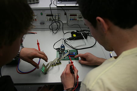 man in white top holding multimeter thumbnail