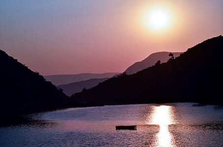 silhouette of boat near mountains thumbnail