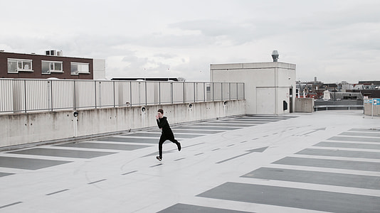 man in black overalls running on building top thumbnail