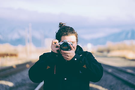 shallow focus photography of man taking photo thumbnail