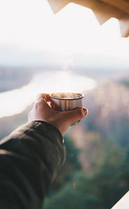 person holding gray stainless steel cup thumbnail