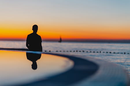 The man is looking at the sunset by the sea thumbnail