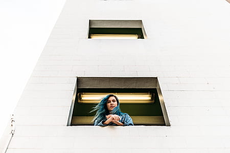 low-angle photograph of woman leaning on wall thumbnail