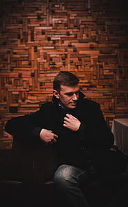 man sitting on chair holding jacket thumbnail