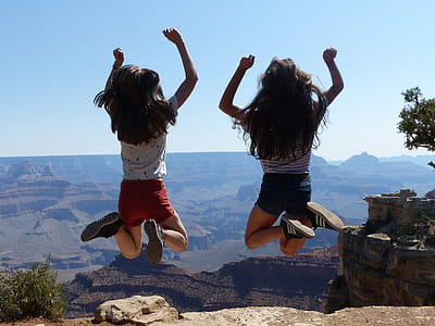 two girl jumping near cliff thumbnail