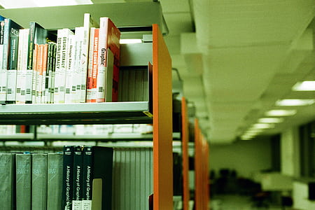 pile of books in grey-and-orange shelves thumbnail