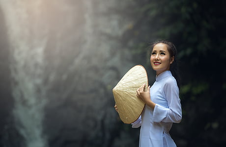 woman holding hat wearing white long-sleeved dress thumbnail