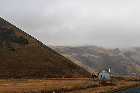 white house in field near mountains thumbnail