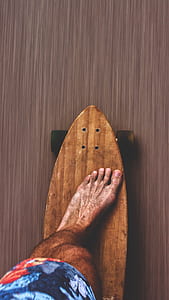 person riding brown wooden longboard thumbnail