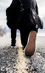 low angle photo of person kneeling on road under gray sky thumbnail