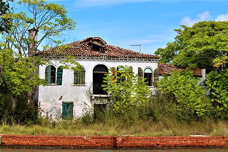 white and brown concrete house surrounded by trees during daytime thumbnail