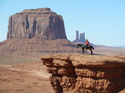 man riding on horse near rock cliff near canyon thumbnail