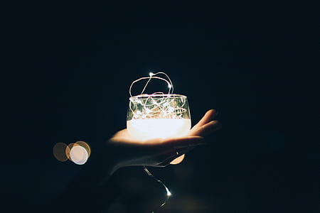 person holding glass with light thumbnail