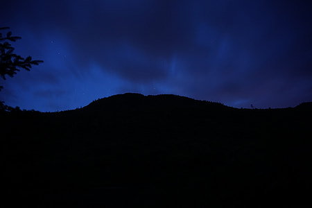 silhouette photography of mountain at nighttime thumbnail