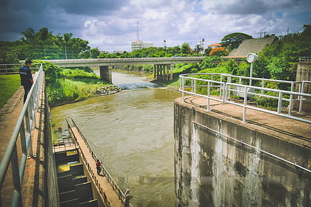 man standing while staring on river during daytime thumbnail
