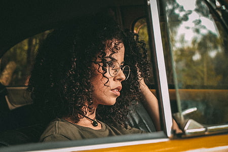 woman sitting on car wearing eyeglasse s thumbnail