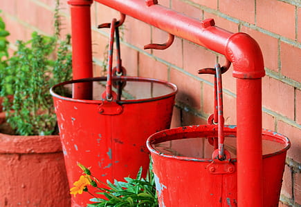two red metal buckets filled with water thumbnail