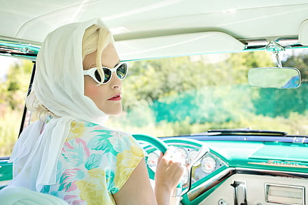 Woman Driving Vintage Car on Road during Daytime thumbnail