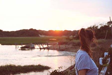 woman standing near body of water thumbnail