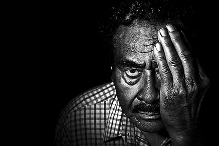 Greyscale Photo of Man in Collared Shirt Covering Left Eye thumbnail