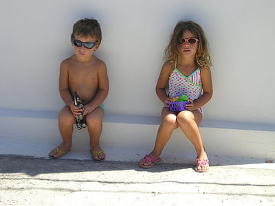 boy and girl sitting on white concrete edge thumbnail