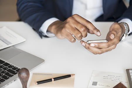 Person Holding Android Smartphone While Leaning on Table thumbnail