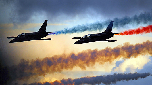 two grey aircrafts with blue and red smokes thumbnail