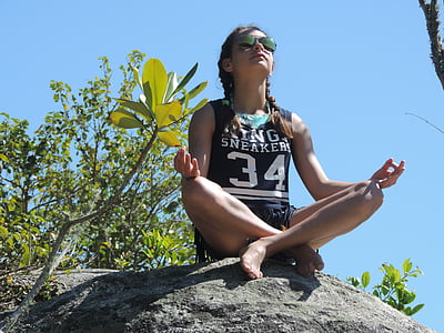 girl in black and white tank top sitting on grey rocks photo taken during daytime thumbnail